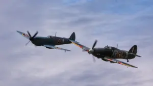 Antrojo pasaulinio karo „Spitfire“ ir „Hurricane“ naikintuvai skrenda danguje per minėjimo renginį.